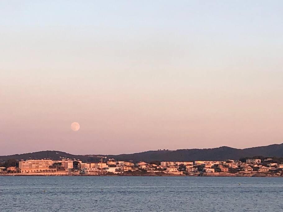 a moonrise over a city and a body of water at Belle vue sur mer, très près du port de Sanary in Sanary-sur-Mer