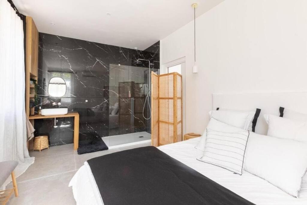 a bedroom with a white bed and a black wall at Belle vue sur mer, très près du port de Sanary in Sanary-sur-Mer