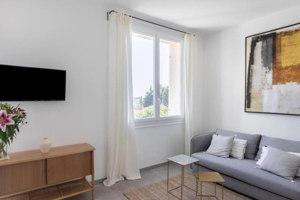 a living room with a couch and a window at Belle vue sur mer, très près du port de Sanary in Sanary-sur-Mer