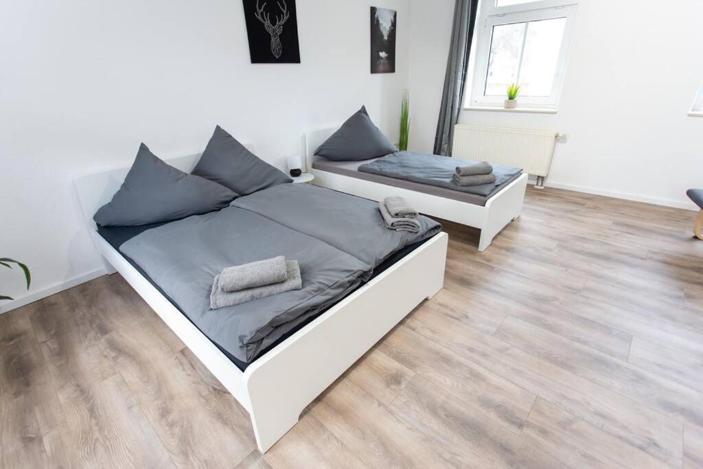 1 Schlafzimmer mit 2 Betten und Holzboden in der Unterkunft Schickes 1-Raum-Apartment mit Balkon und vollausgestatteter Küche in Chemnitz