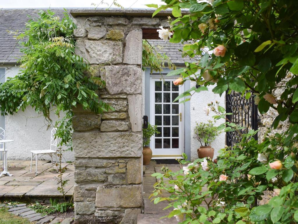 a stone house with a white door and a porch at Easter Baldinnies in Forteviot