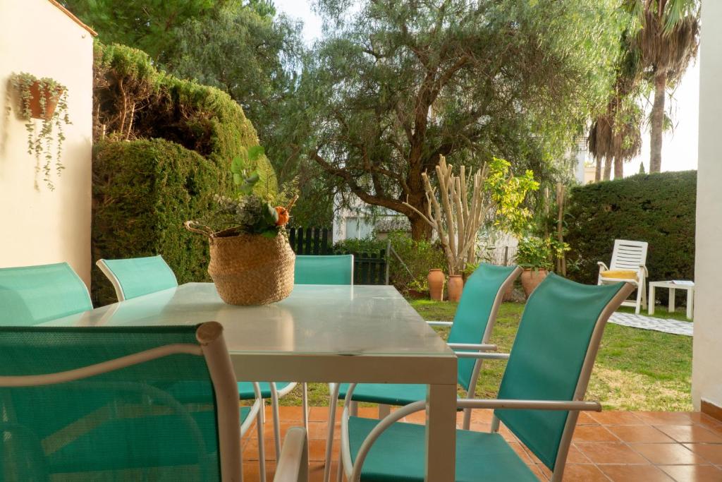 una mesa con sillas y un jarrón encima en R&B Vistahermosa Garden, en El Puerto de Santa María