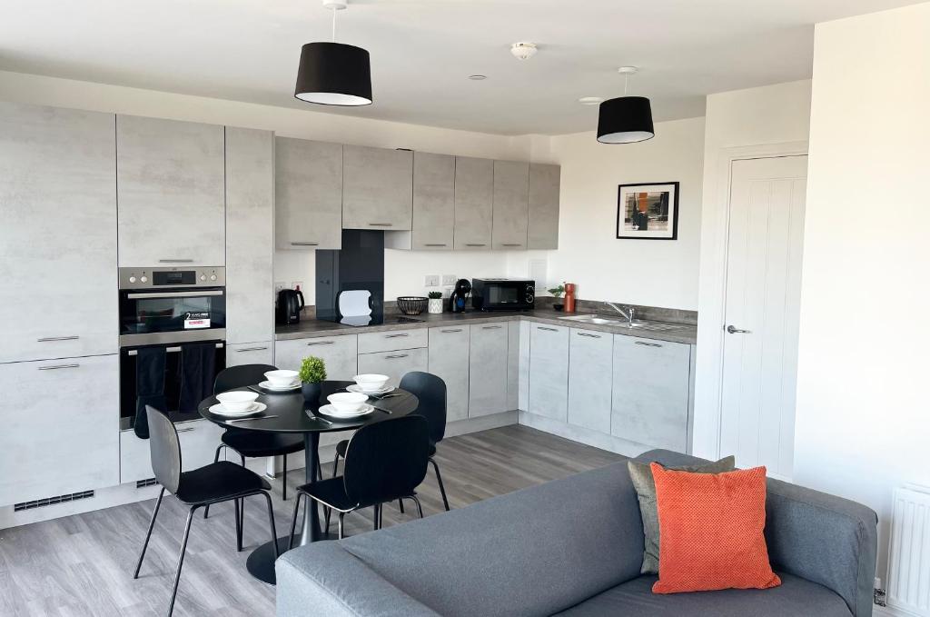 ein Wohnzimmer mit einem Sofa und einem Tisch in der Küche in der Unterkunft Riverside Apartment Chelmsford in Chelmsford