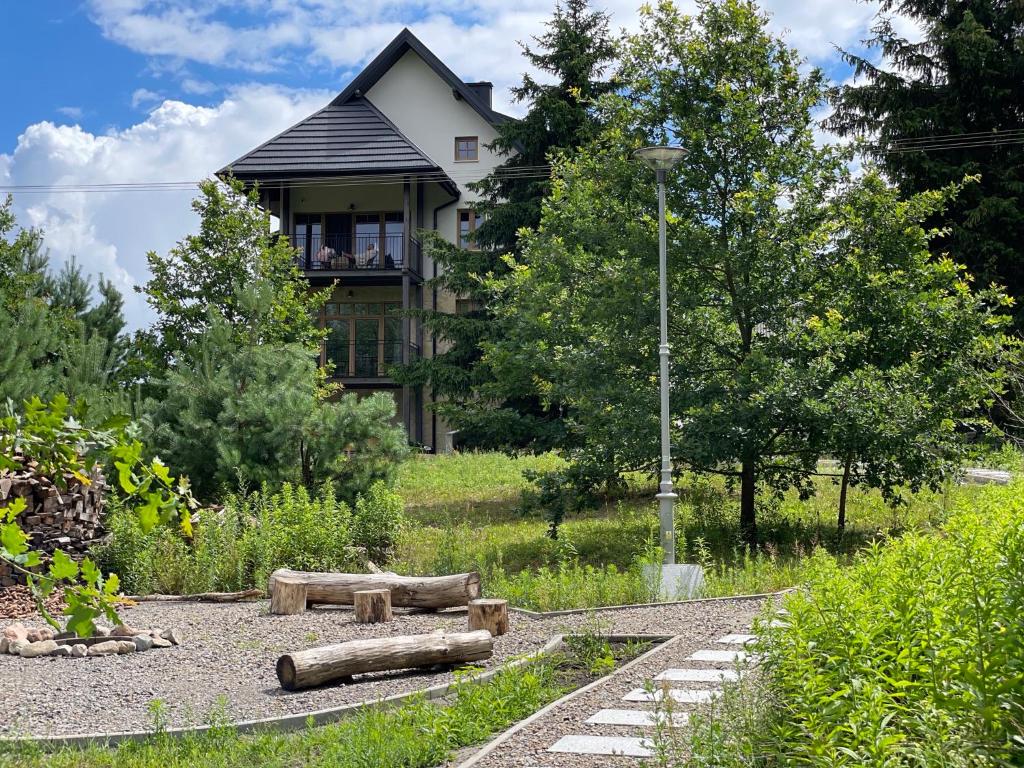 une maison au milieu d'un jardin en face d'une maison dans l'établissement Siedlisko Marianna, apartamenty Janowiec, Kazimierz Dolny, à Ławecko