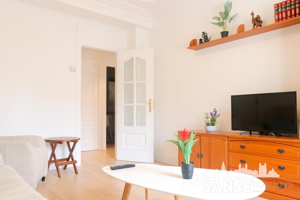 a living room with a tv and a table at Apartamento Colón by SanSe Holidays in San Sebastián