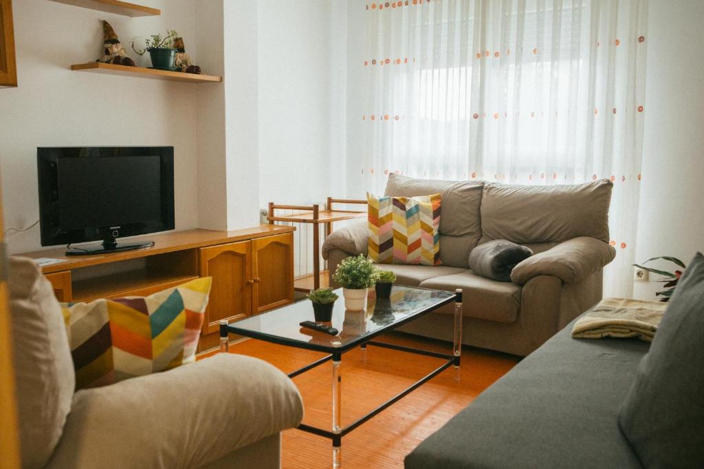 sala de estar con 2 sofás y TV en A Solaina en Redondela