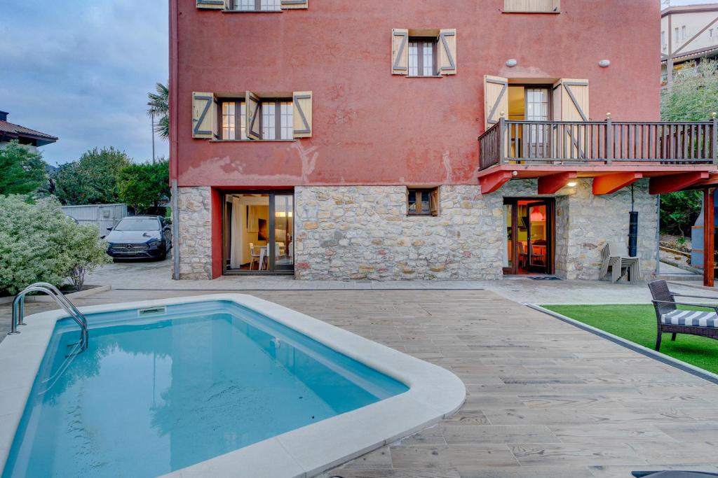 a house with a swimming pool in front of a building at Villa Oasis by SanSe Holidays in San Sebastián