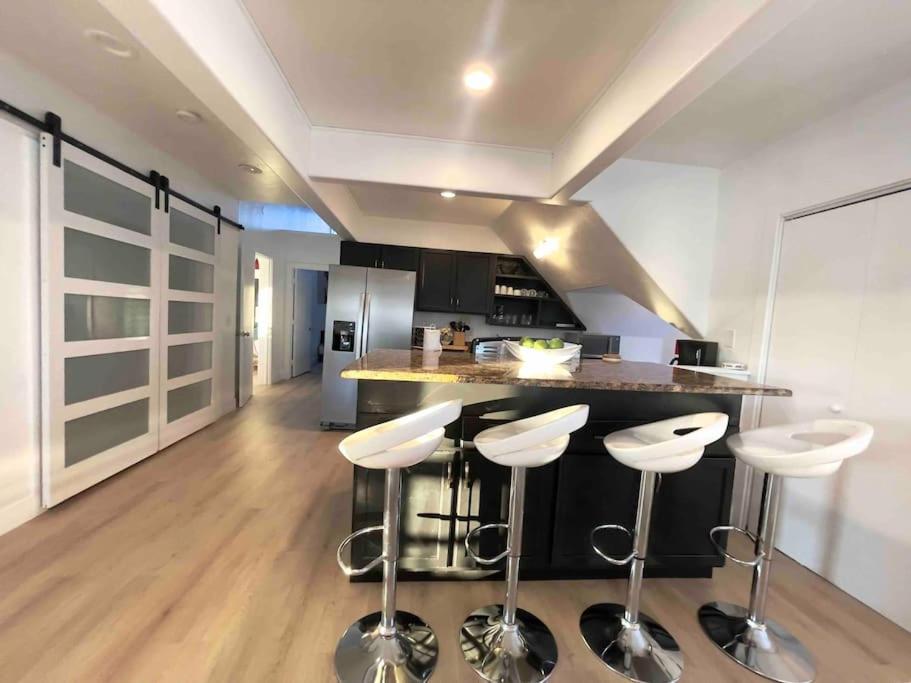 a kitchen with a counter and stools in a room at Downtown Sunny Penthouse ! in Denver