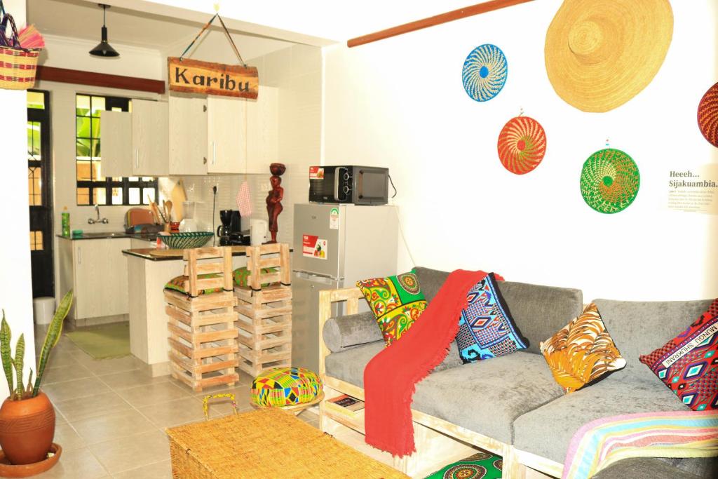 a living room with a couch and a kitchen at Wakanda@HeArt Stays in Kakamega