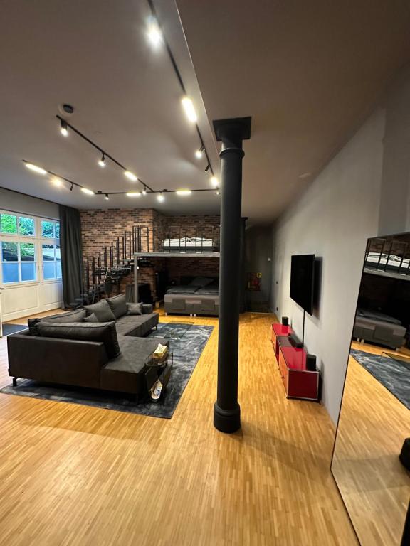 a living room with a black couch and a fireplace at Loft mit privater Sauna in Heidelberg