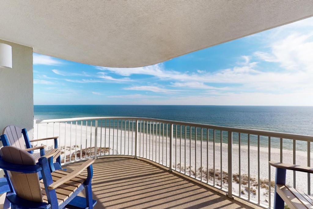 Un balcón con sillas y vistas al océano. en Tradewinds 601, en Orange Beach