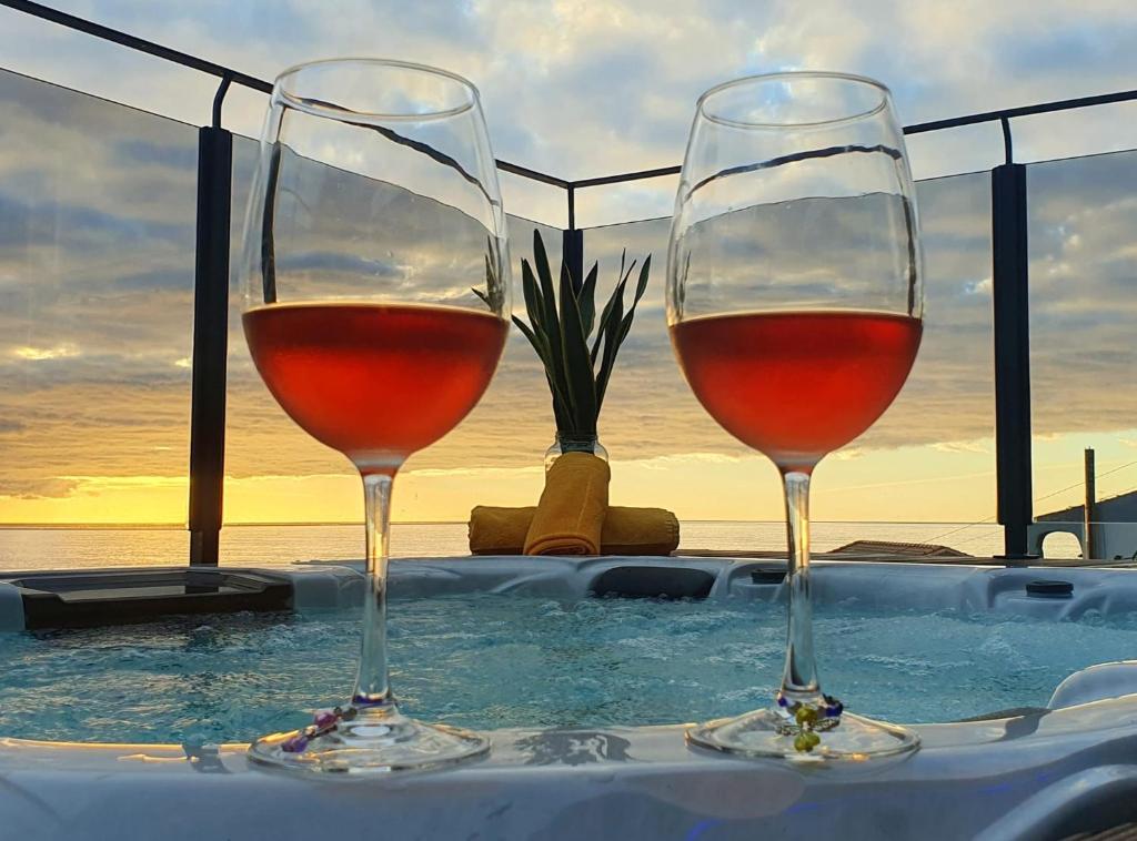 Dois copos de vinho em cima de uma banheira em Casa da Rocha em Paul do Mar