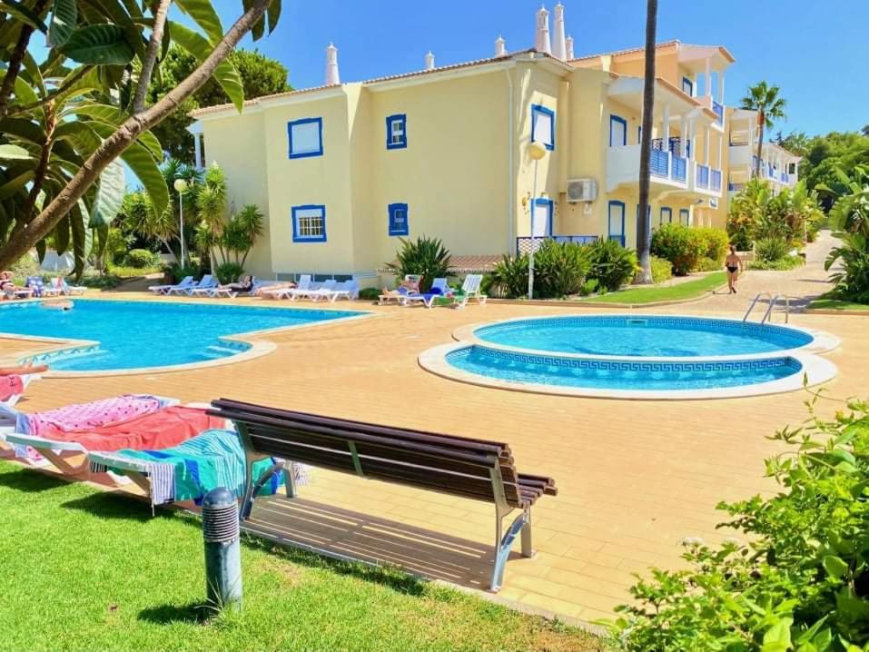 eine Villa mit einem Swimmingpool vor einem Haus in der Unterkunft Flamingos Apartment with 2 swimming pool com check in e check out ao domingo em julho e agosto in Albufeira