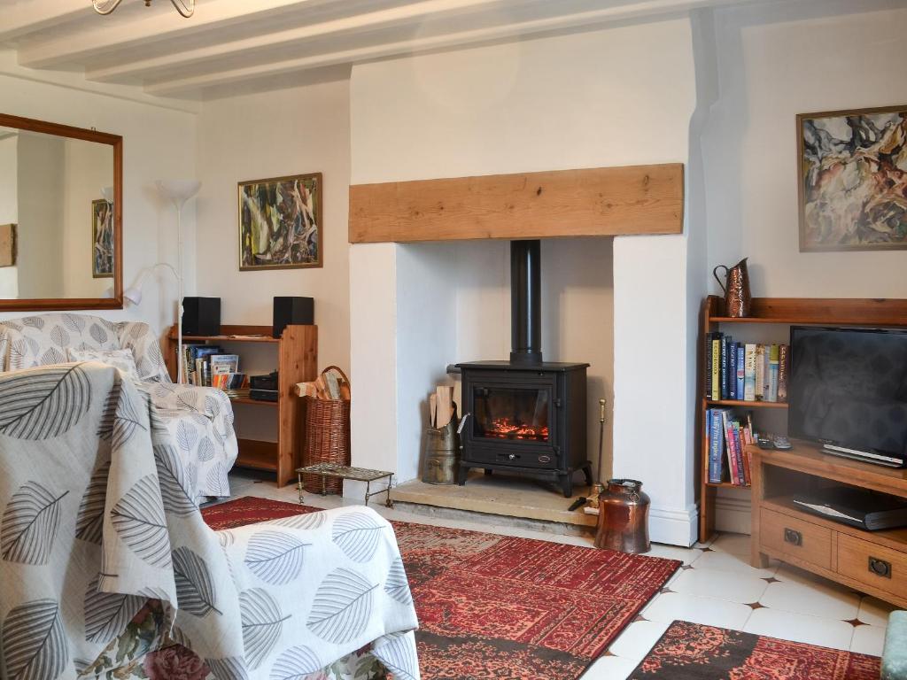 a living room with a fireplace and a bed at Heckberry Cottage in Burtree Ford