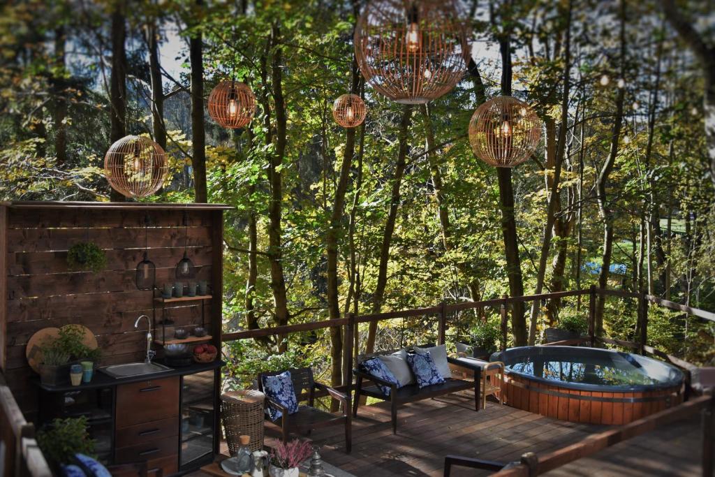 a deck with a hot tub and chairs and chandeliers at Oto Widoki in Szklarska Poręba