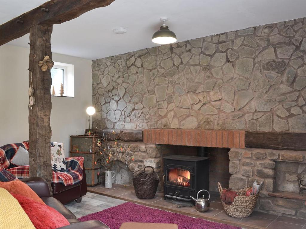 a living room with a stone wall with a fireplace at Fourwinds in Farlow