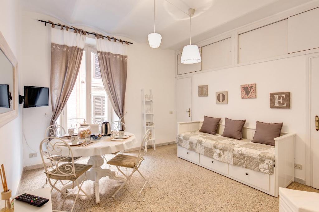 a white bedroom with a bed and a table at Casa Dolce Casa in Rome
