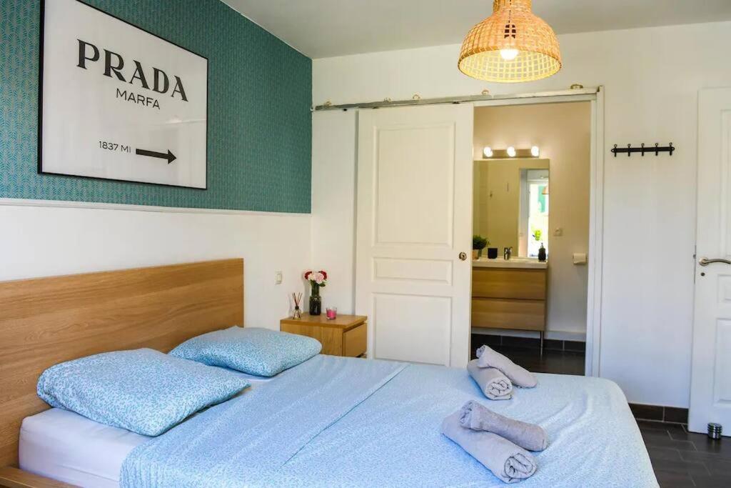 - une chambre avec 2 oreillers bleus sur un lit dans l&#39;établissement Le Capé-Grand appartement avec terrasse et jacuzzi, à Marseille