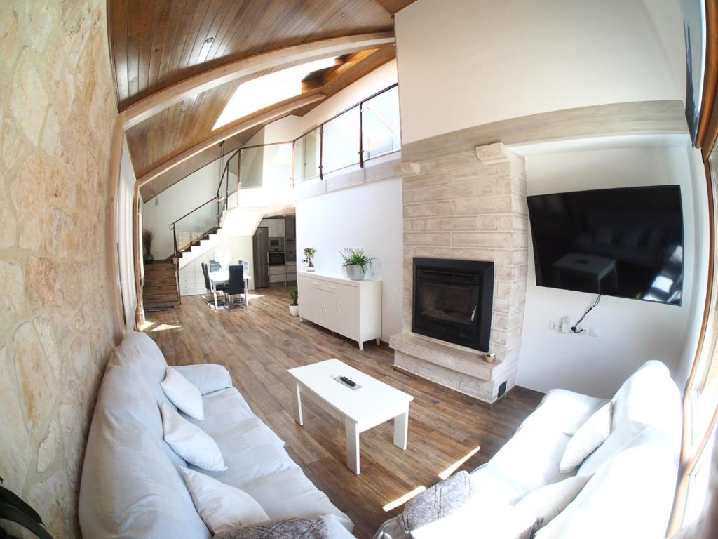 un salon avec un canapé blanc et une cheminée dans l'établissement EL Rincón de Lola, à Carboneras de Guadazaón