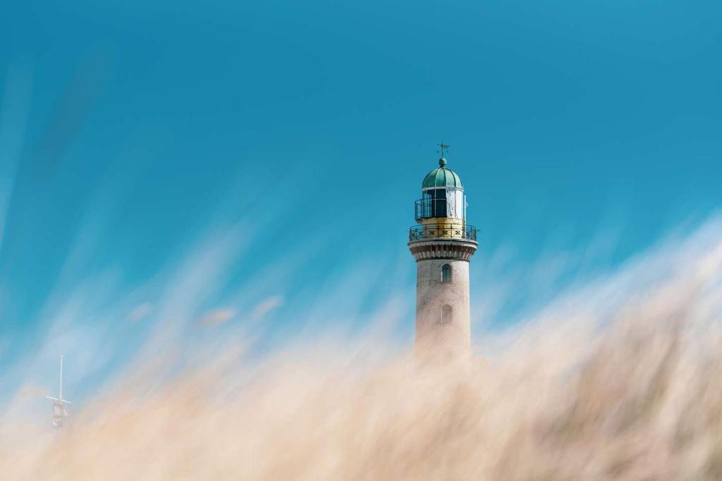 un faro seduto sopra un palazzo alto di LIGHTHOUSE APPARTEMENTS a Warnemünde