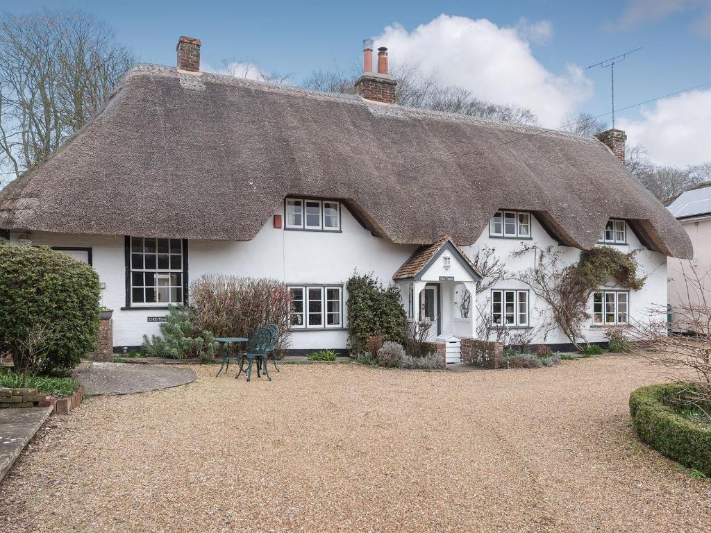a white house with a thatched roof at Little Trout in Middle Wallop