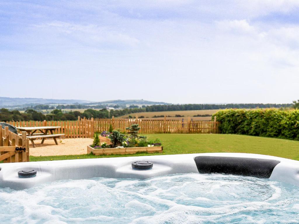 a jacuzzi tub in a yard with a backyard at Jasmine Cottage in Knitsley