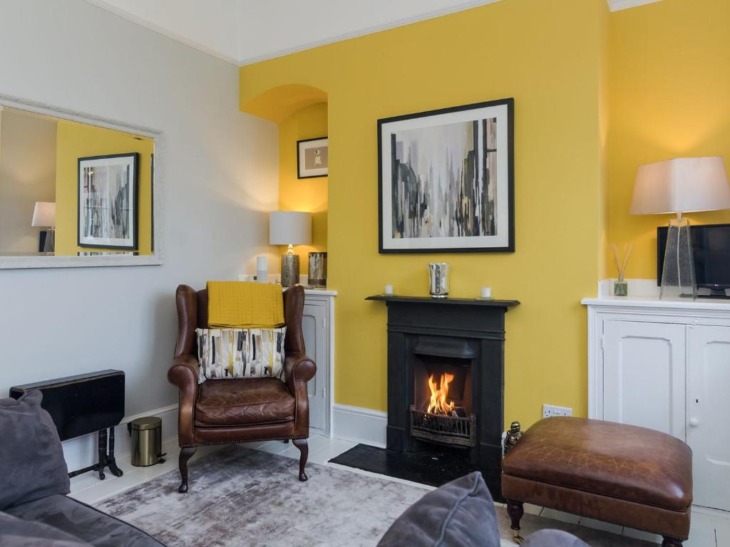 a living room with yellow walls and a fireplace at Coastguard Retreat in Ramsgate