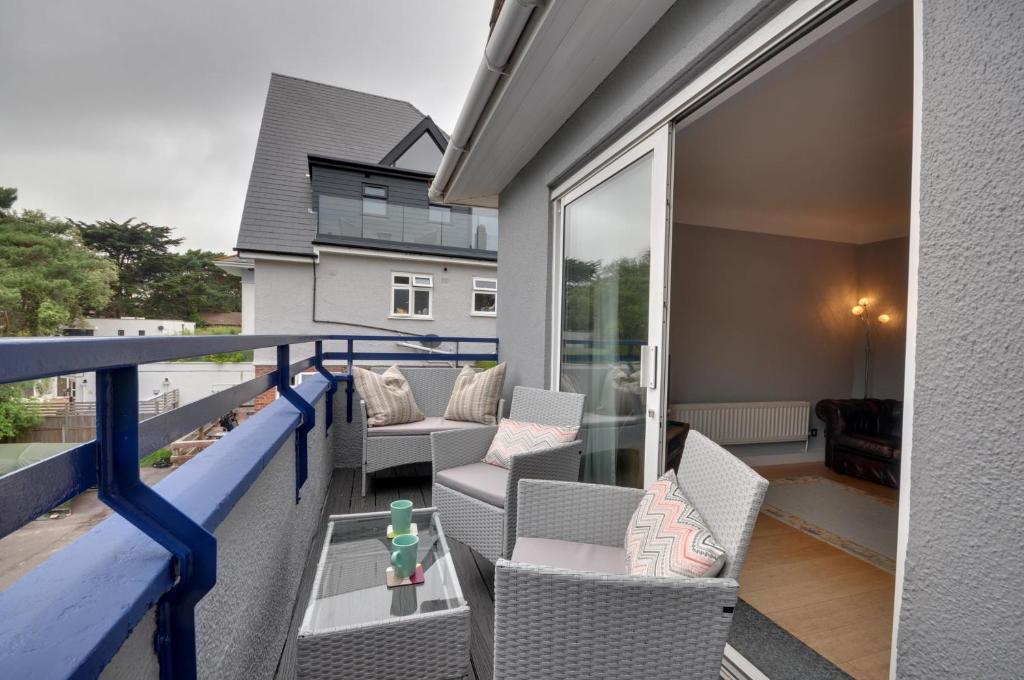a balcony with chairs and tables on a house at Mauve in Poole