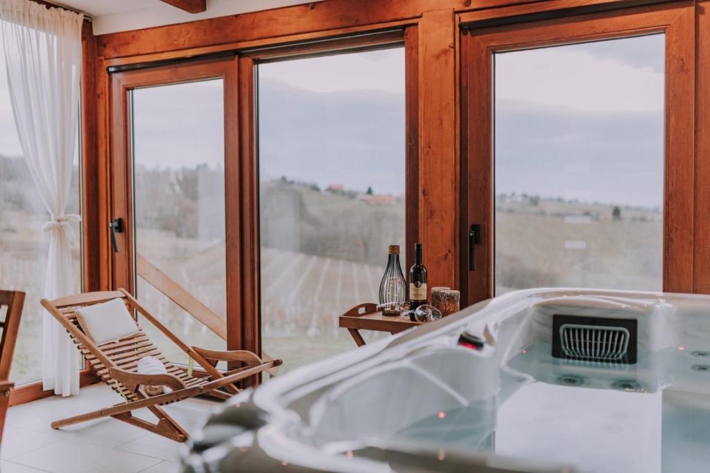 a room with a tub and a chair and windows at Holiday home The view in Sveti Urban