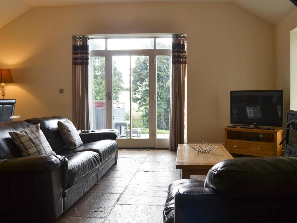Durham Cottage-27765 في Wolsingham: غرفة معيشة مع أريكة وتلفزيون