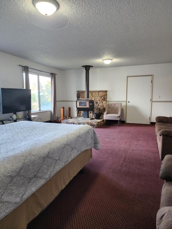 a hotel room with a bed and a fireplace at Plainview Motel in Coos Bay