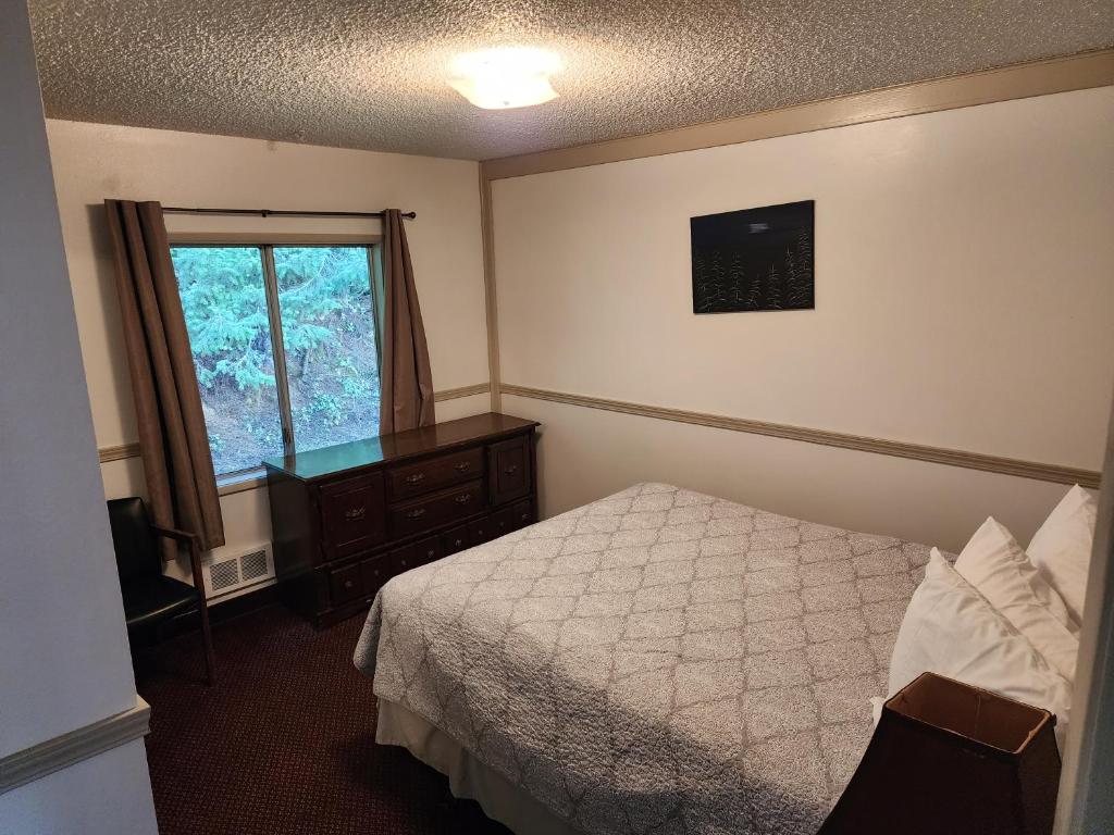 a hotel room with a bed and a window at Plainview Motel in Coos Bay