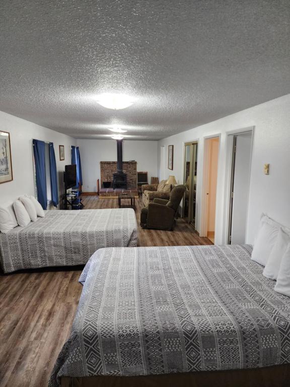 a hotel room with two beds and a living room at Plainview Motel in Coos Bay