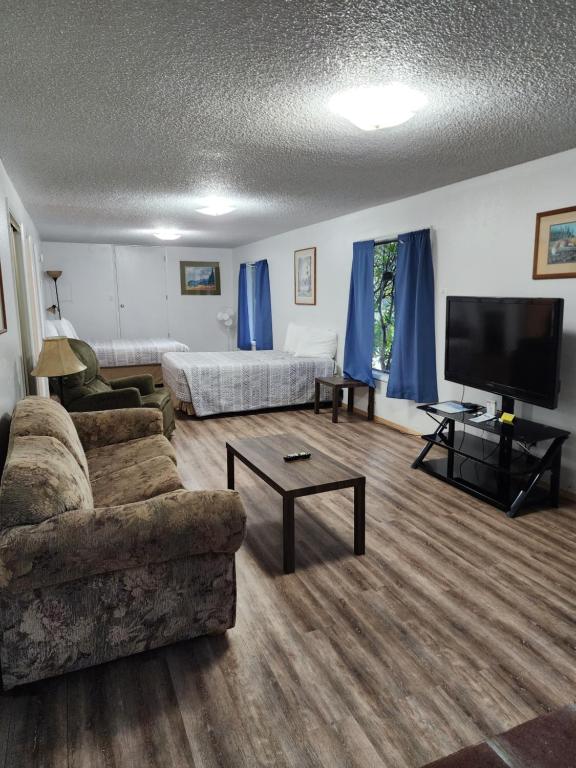 a living room with a couch and a flat screen tv at Plainview Motel in Coos Bay