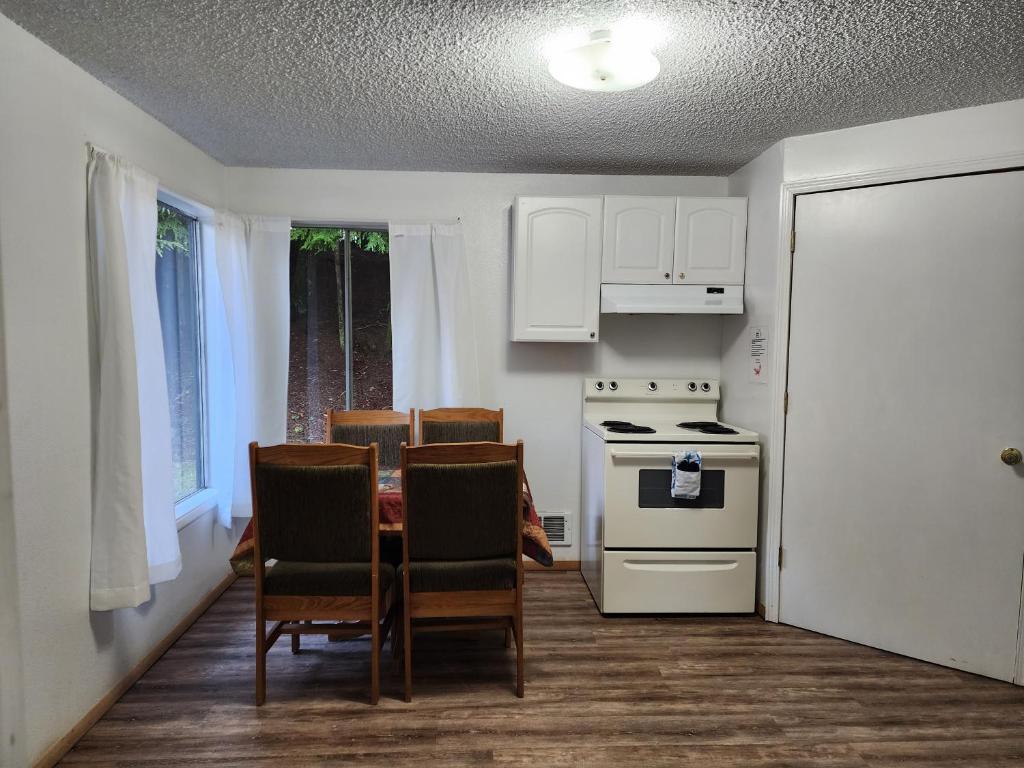a kitchen with a table and chairs and a stove at Plainview Motel in Coos Bay