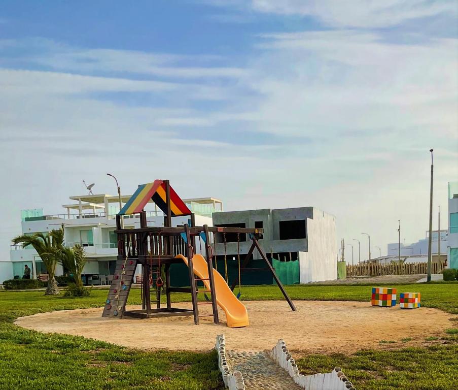 a playground with a slide in a park at Solymar Beach House - Paracas in Paracas