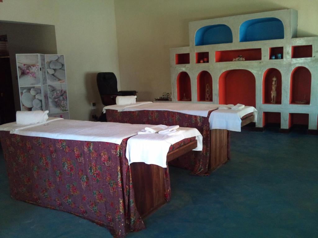 a group of three beds in a room at Serenity on the Lake in Kalemera