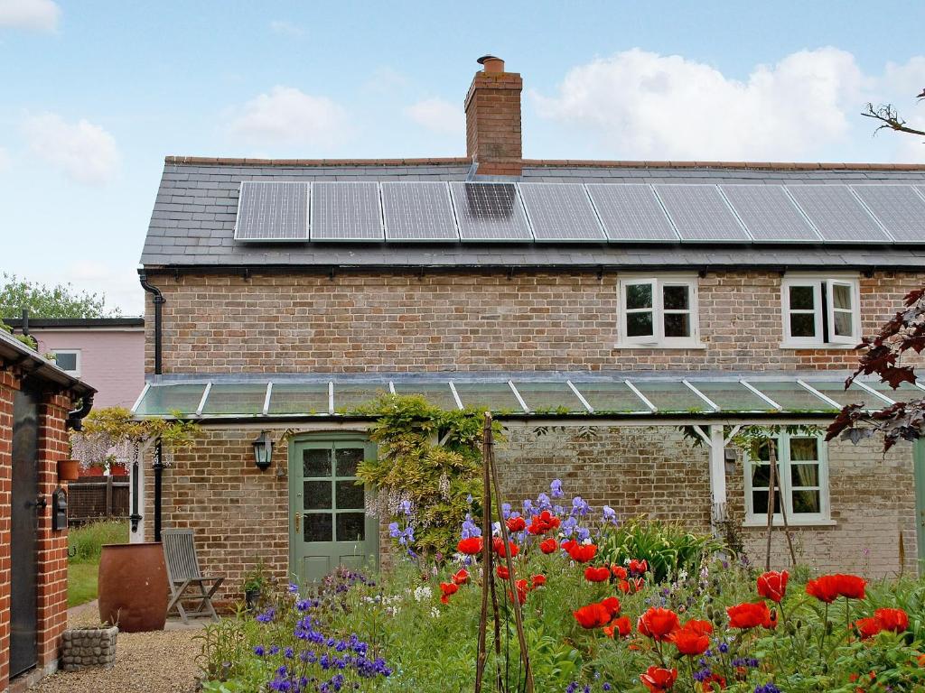 a house with solar panels on the roof at The Cottage in Great Blakenham