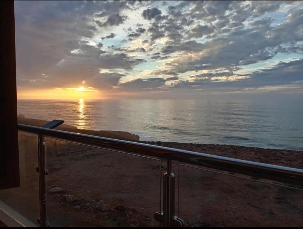 a view of the ocean with the sunset in the background at Dar diafa samira in Mirleft