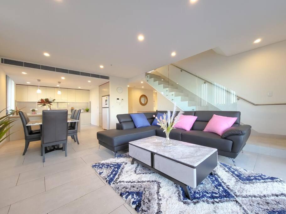 a living room with a couch and a table at Spacious 3-Bed Penthouse with Perfect View in Sydney