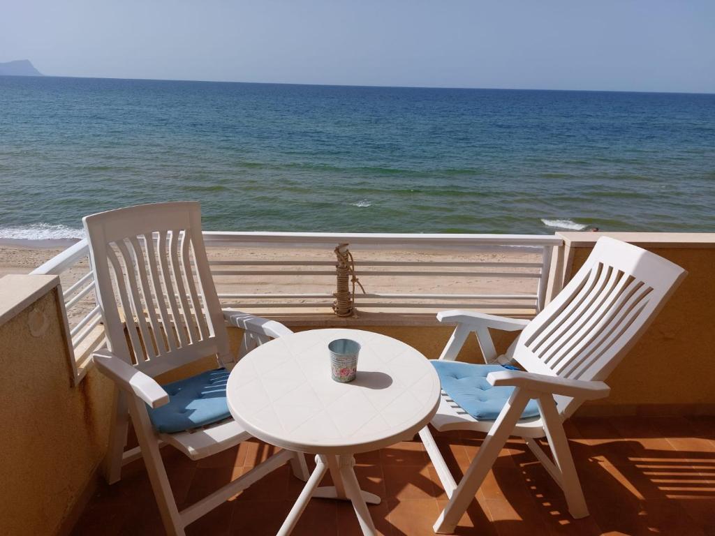 duas cadeiras e uma mesa numa varanda com o oceano em Flora em Alcamo Marina