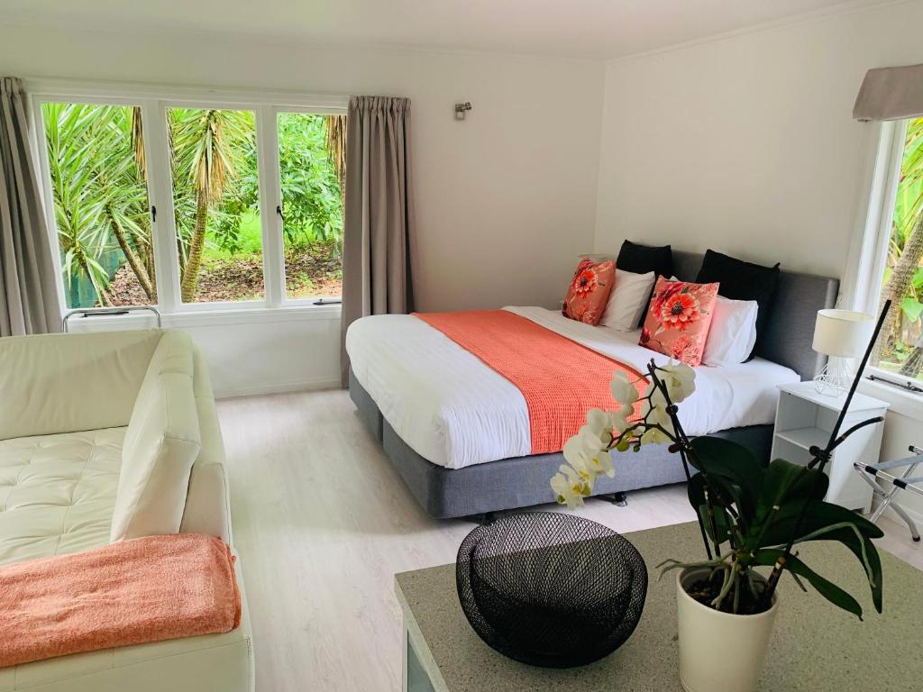 ギズボーンにあるLa Frontiere Boutique Accommodationのベッドとソファのある寝室