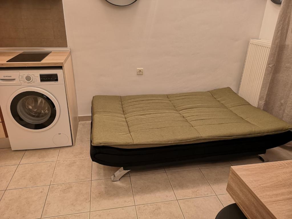 a bed in a room with a washing machine at Serres Kavafi 7 city center , FREE PARKING , FREE NETFLIX in Serres