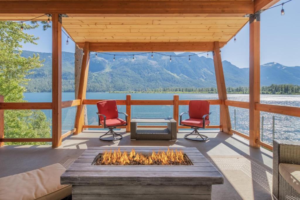 a screened in porch with a fire pit and chairs at Lazy Bear Lodge by NW Comfy Cabins in Leavenworth