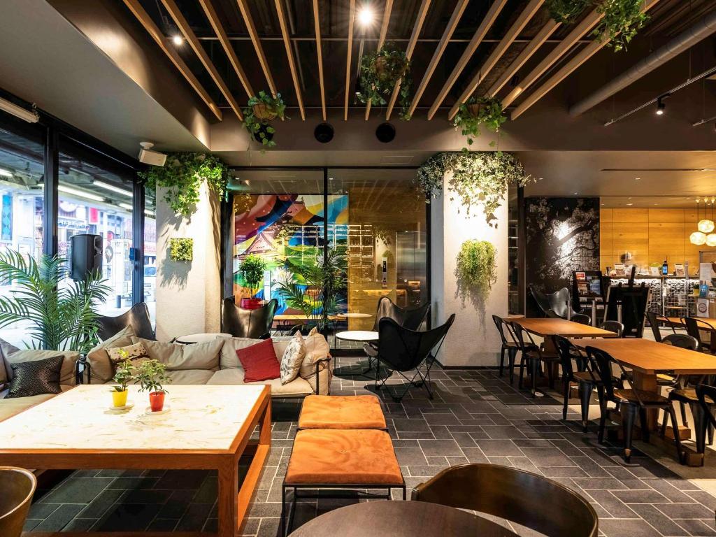 - un restaurant avec des tables, des chaises et un canapé dans l'établissement ibis Osaka Umeda, à Osaka