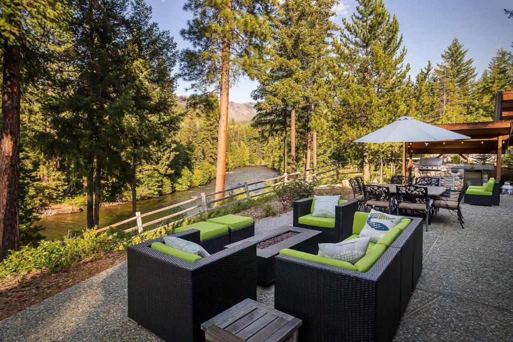 a patio with couches and a table and chairs at Riffle River Lodge by NW Comfy Cabins in Leavenworth