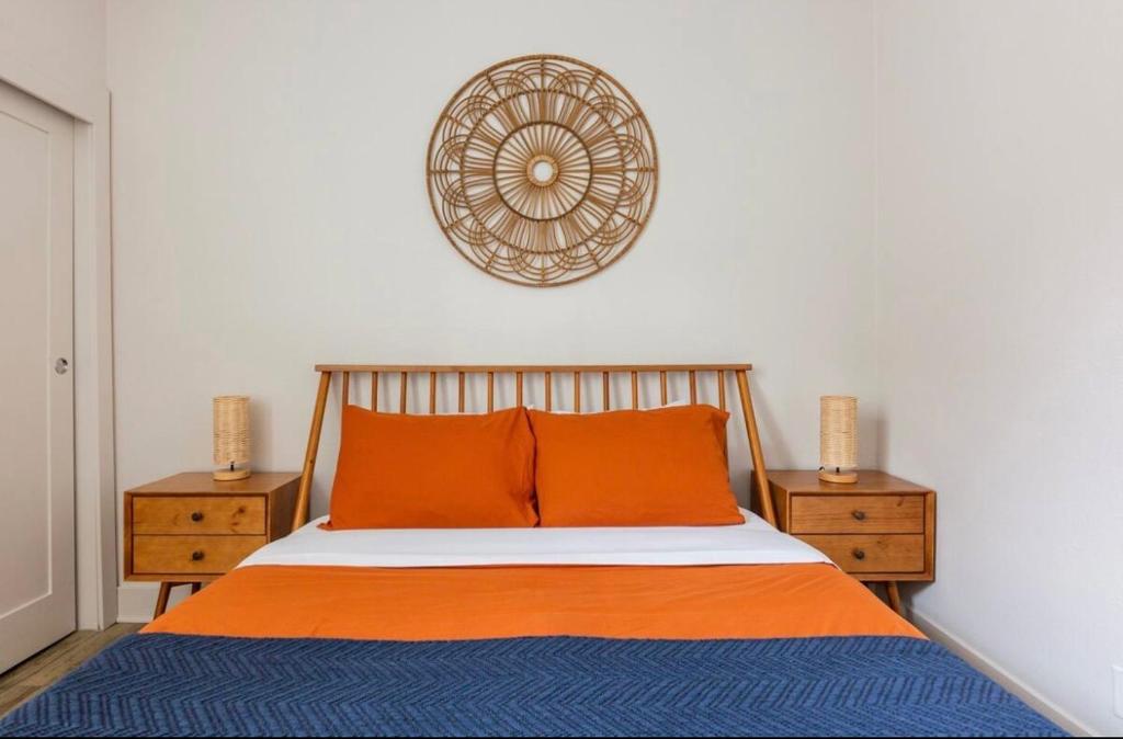 a bed with orange and blue sheets and two night stands at Tulum Vibes 1 Bedroom Apartment near Boats in Marina Del Rey in Los Angeles