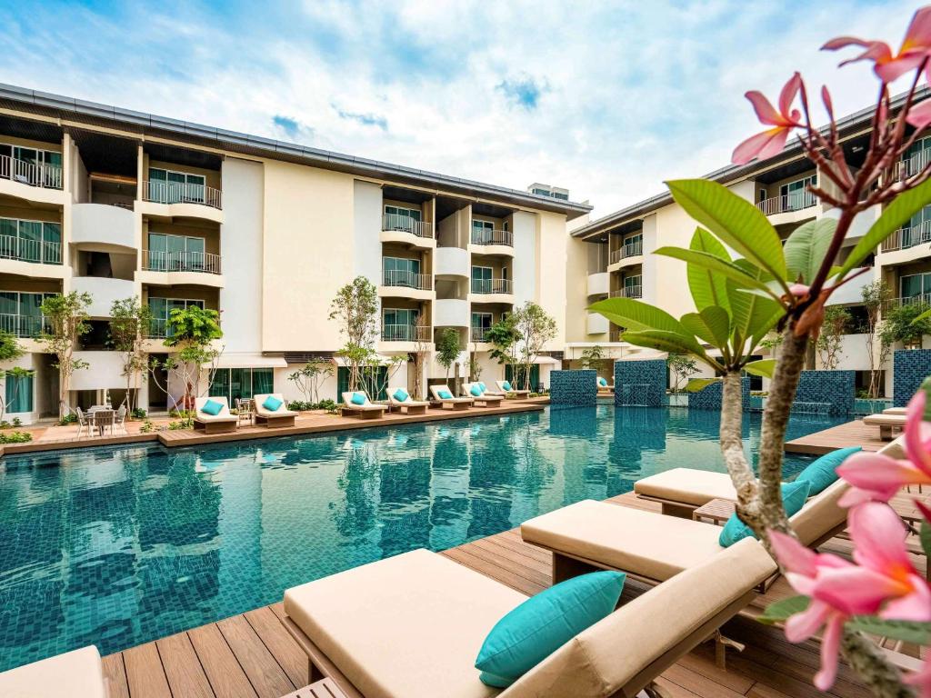 珍南海滩Mercure Langkawi Pantai Cenang的酒店游泳池设有躺椅,度假村