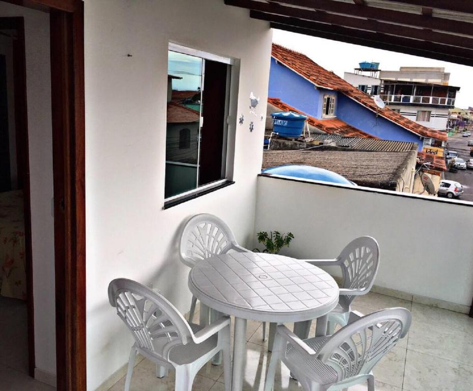 - Balcón con mesa blanca y sillas en ALUGO CASA INTEIRA EXCELENTE Casa de temporada em Cabo Frio, en Cabo Frío