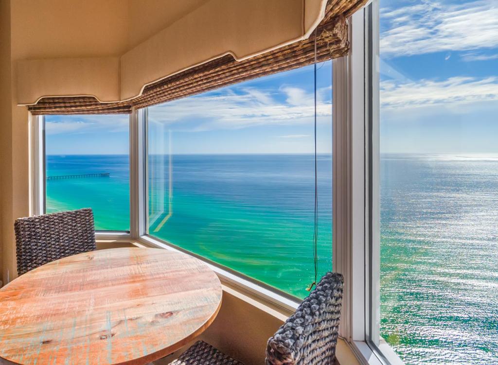 a table and chairs in front of a large window at Tidewater2808 in Panama City Beach